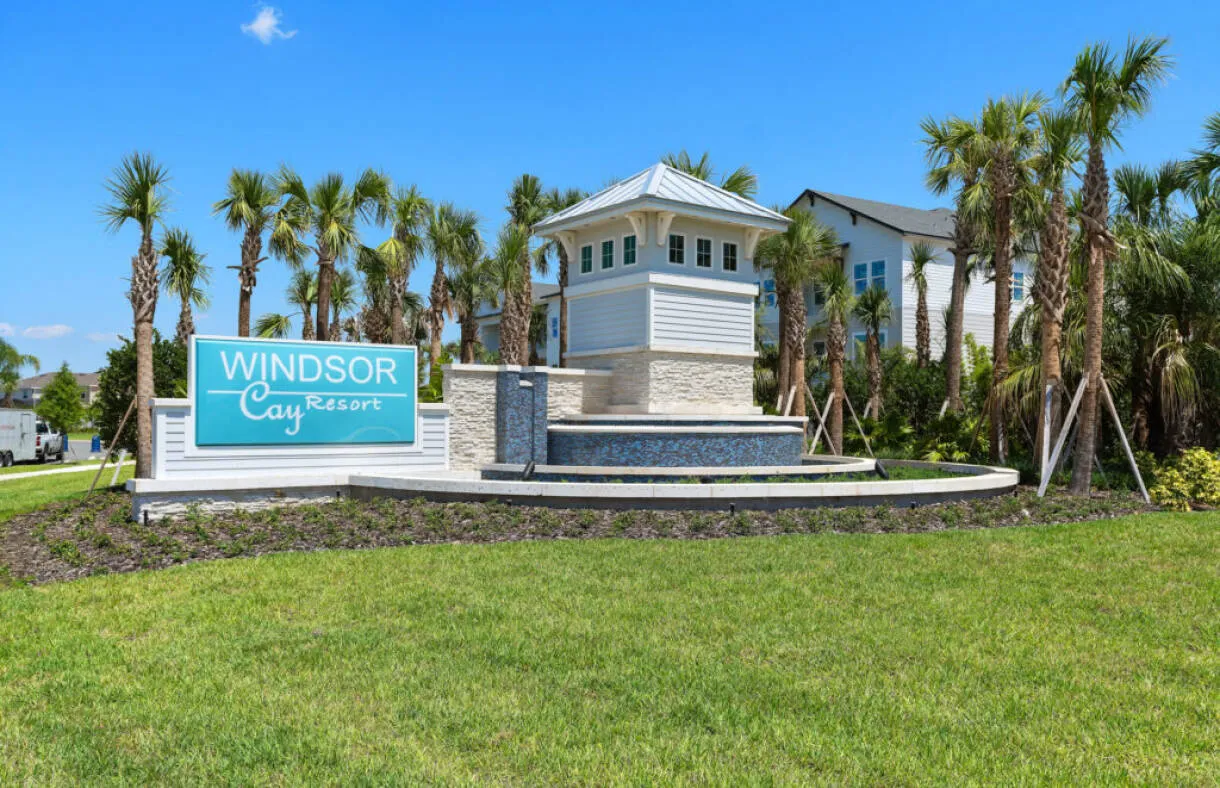 Windsor Cay Resort entrance monument sign framed by palm trees.