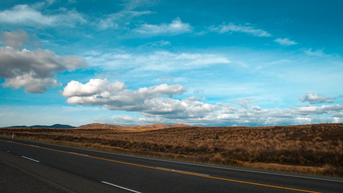An open highway stretching toward the horizon under a blue sky